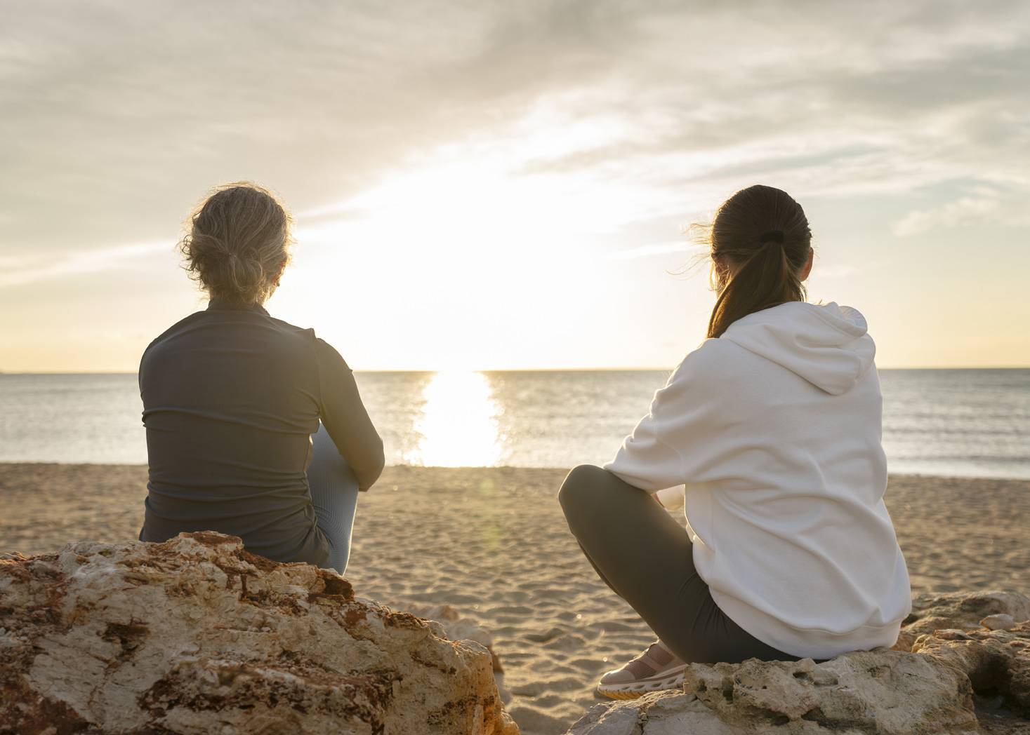 full-shot-women-sitting-beach.jpg